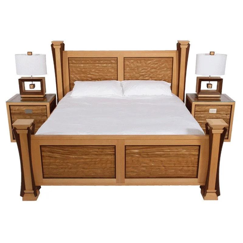 Wooden bed with white bedding, two bedside tables with lamps on each side, against a plain white background.