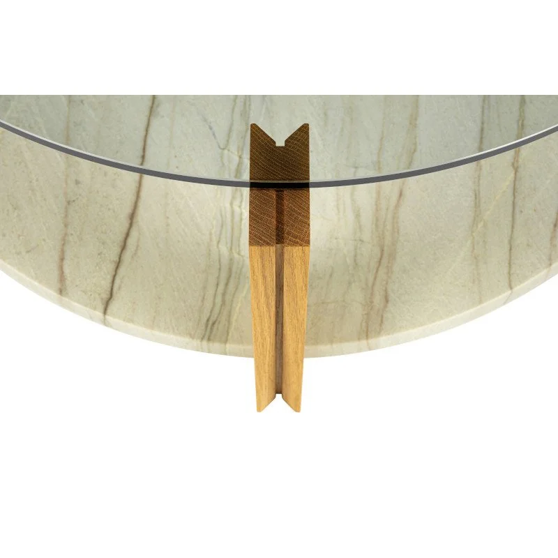 Close-up of a round marble table with a glass top and wooden support.