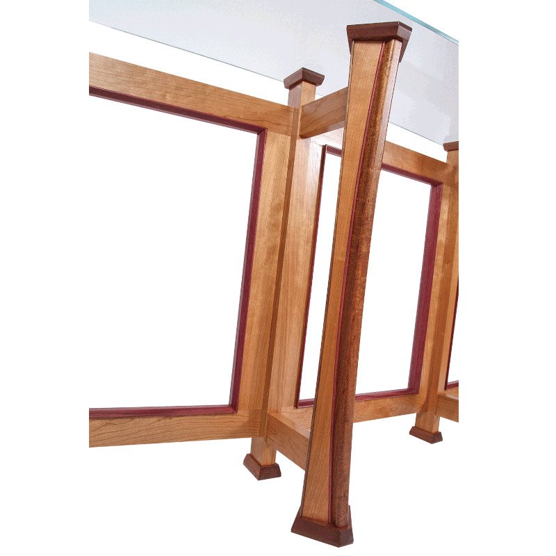 Close-up view of a wooden table or desk frame with a glass top.
