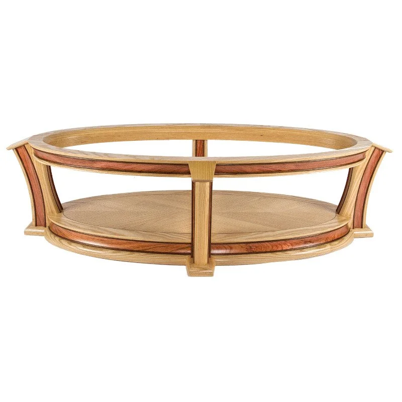 Wooden oval-shaped table, featuring a light wood finish with reddish accents.