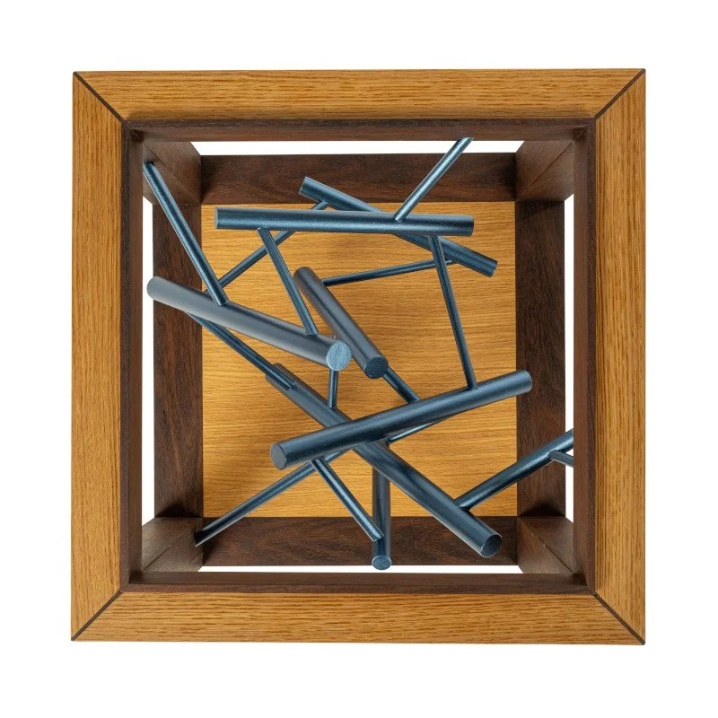 Top view of a custom side table with a painted dowel rod sculpture inside of it.