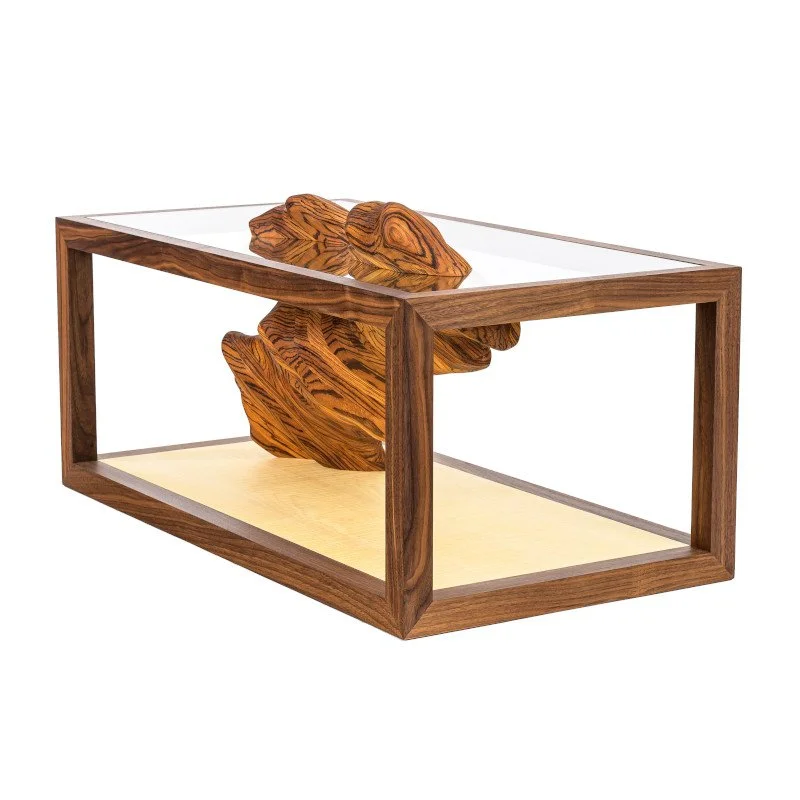 A bespoke wood and glass coffee table with a layered wooden sculpture inside
