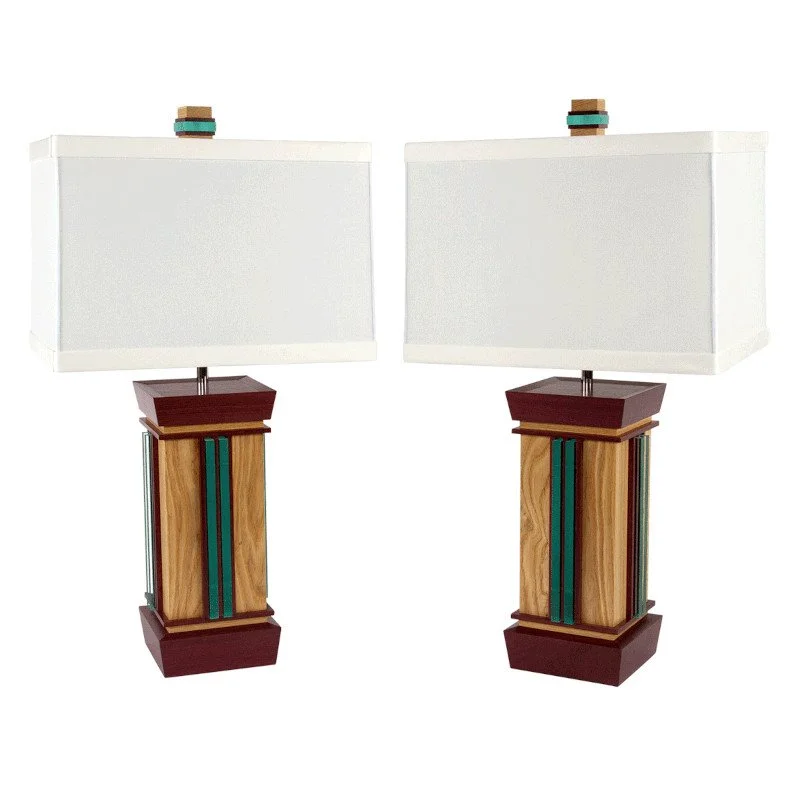 Pair of custom wooden table lamps with rectangular white lampshades and decorative elements on top, against a plain white background.