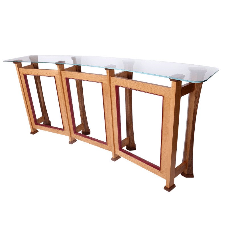 A wooden table with a glass top and open rectangular base design.
