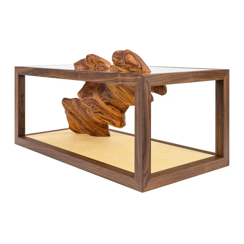 A wood coffee table with a wooden sculpture inside.