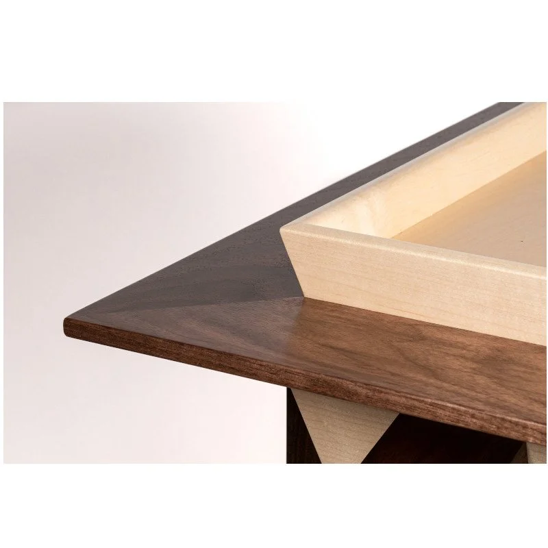 Close-up of a wooden table corner with layered wood design in dark and light wood tones.