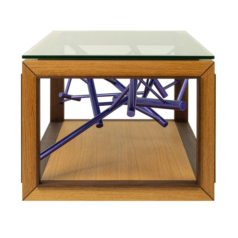 A modern coffee table with a glass top, wooden frame, and a tangled purple metallic like sculpture underneath.