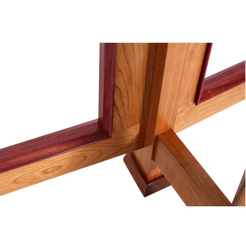 Close-up of a wooden table corner with a combination of light and dark wood grains.