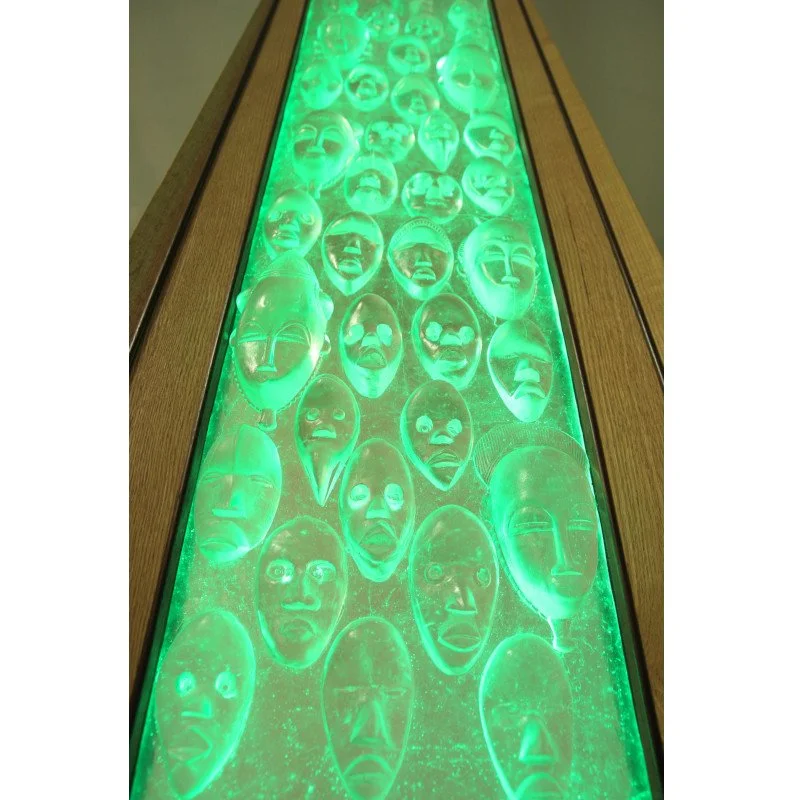 Art glass display of tribal masks illuminated with green LED light in custom wood frame.
