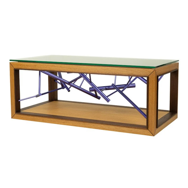 A modern coffee table with a glass top, wooden frame, and a sculpture made of purple metallic painted dowel rods.