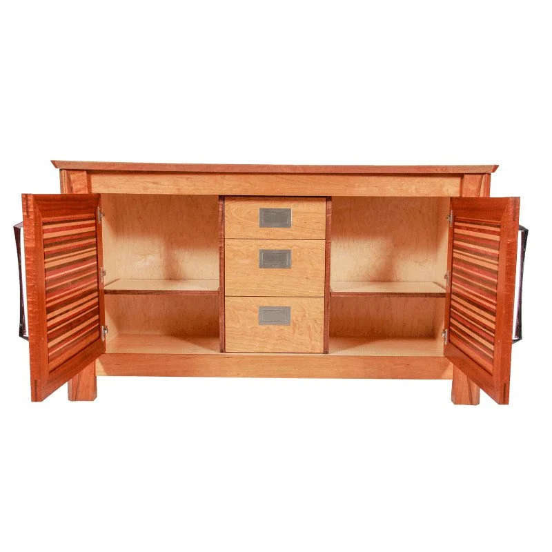 A wooden cabinet with two doors open, revealing an empty interior with one shelf on each side and three central drawers.