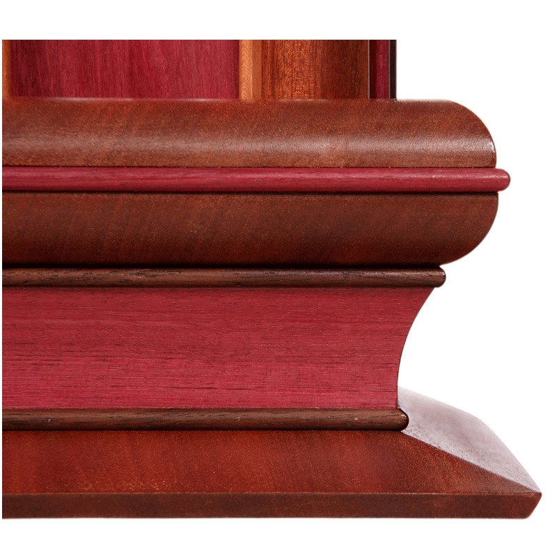 Close-up of the corner of a wooden lamp base with curved and layered wooden elements in reddish-brown finish.