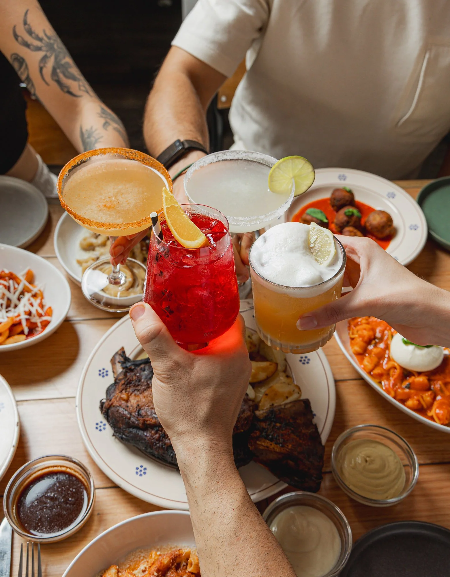 photo of a group of people cheering with cocktails at Alba, the best Italian restaurant for groups in Newtown