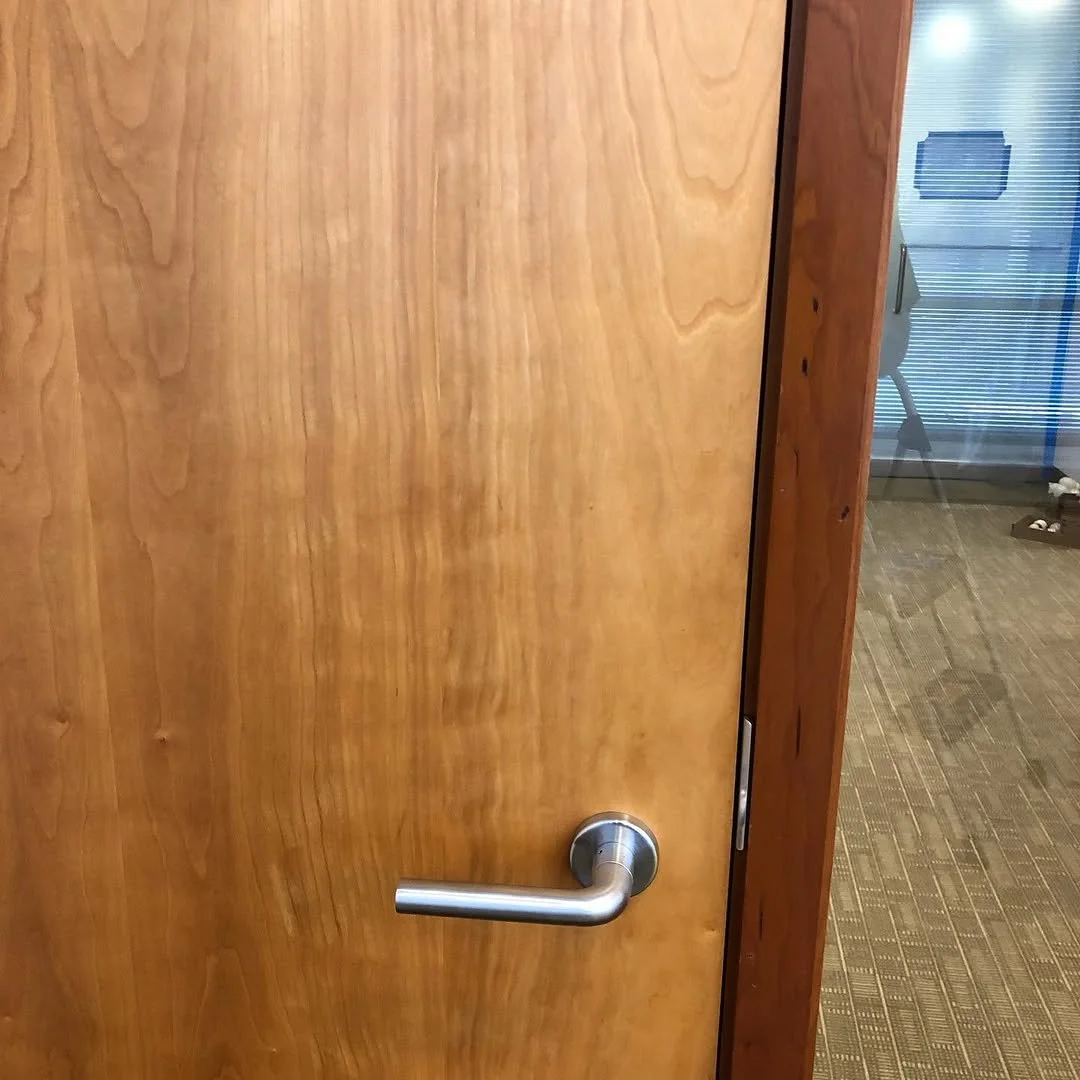 Close-up of a wooden door with a silver door handle.