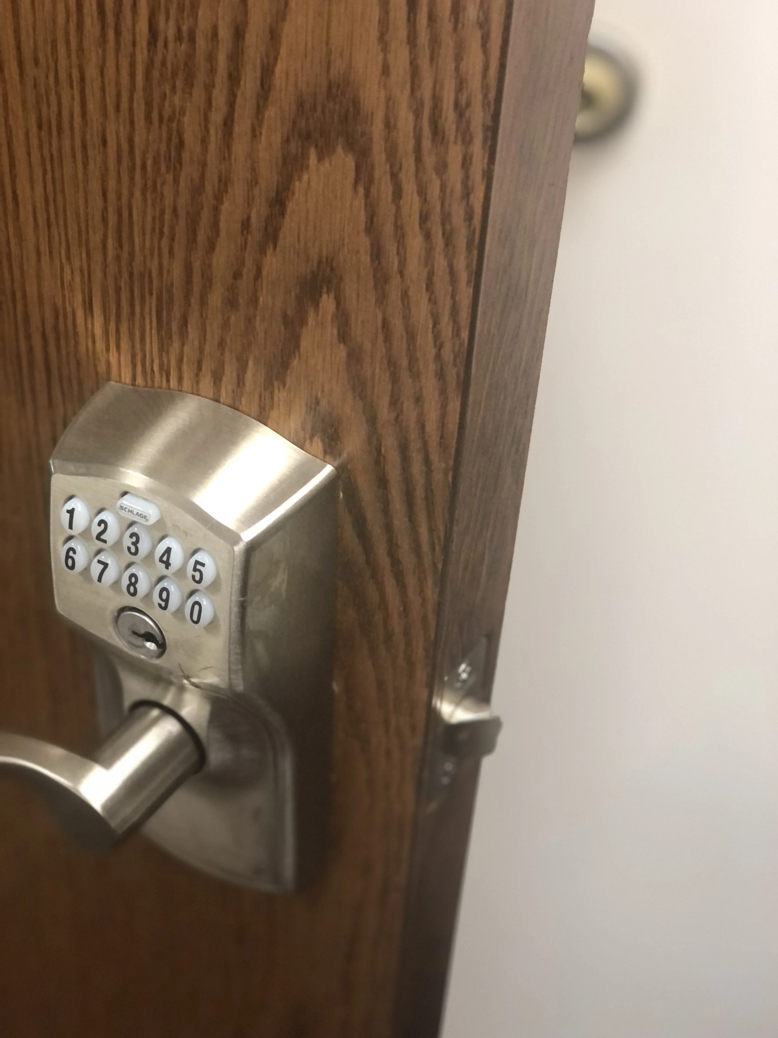 A close-up of a digital keypad lock with a numeric keypad on a wooden door