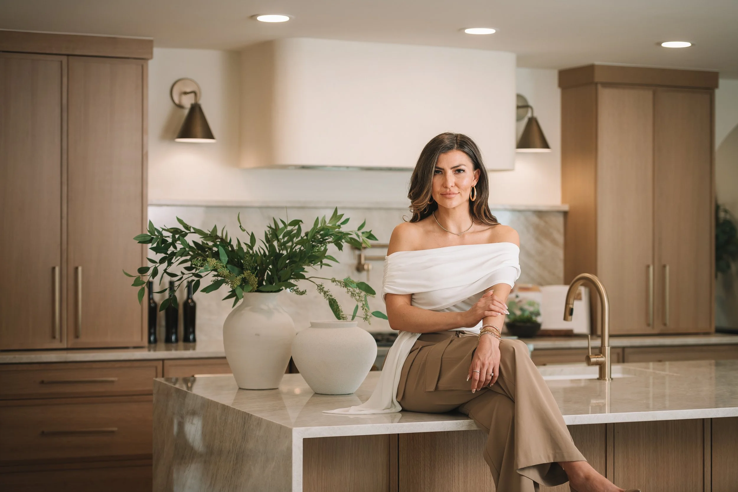Ashley Lowery of The Lowery Group seated in a modern luxury kitchen.
