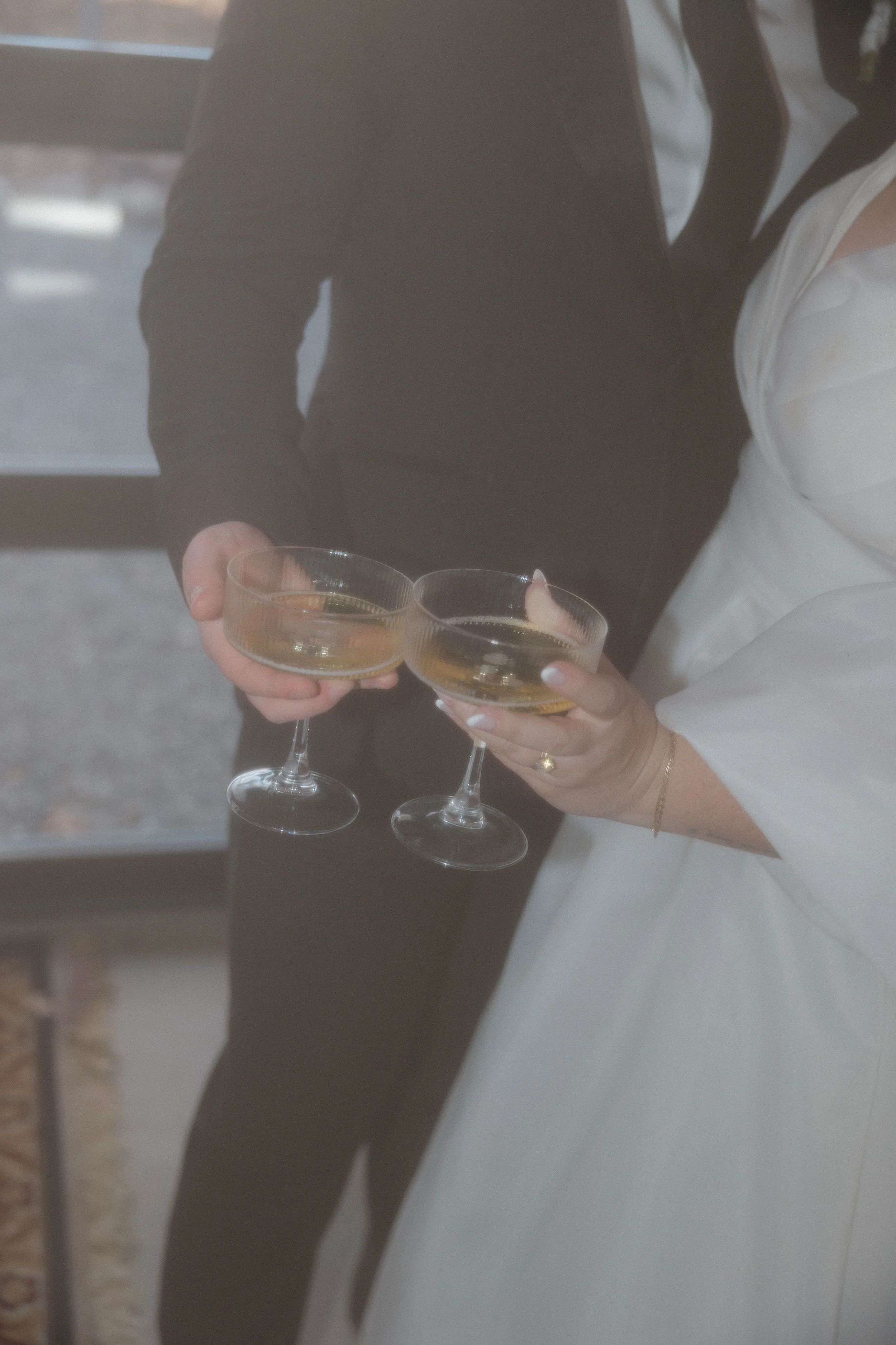 Two people are clinking glasses filled with champagne during a celebration or special occasion.