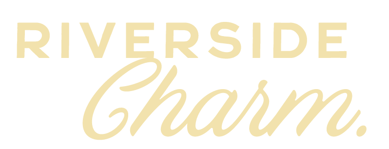 Text saying "RIVERSIDE Charm." with "RIVERSIDE" in bold uppercase and "Charm" in cursive script.