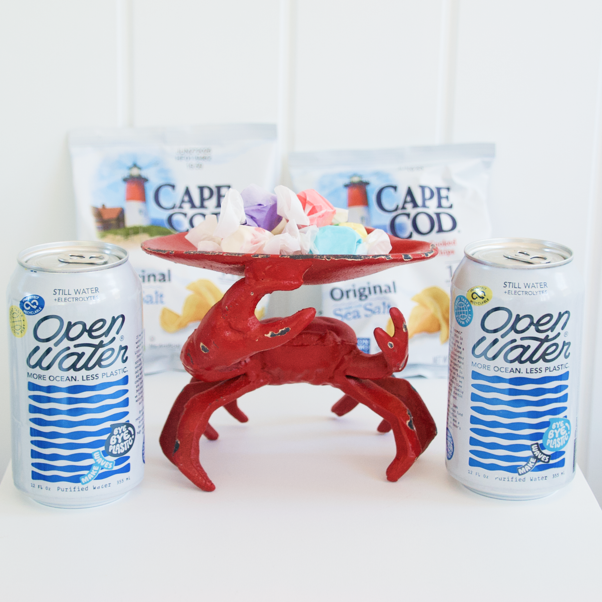 Little Gay Inn guest check in gifts, two cans of water, salt water taffy, and cape cod chips
