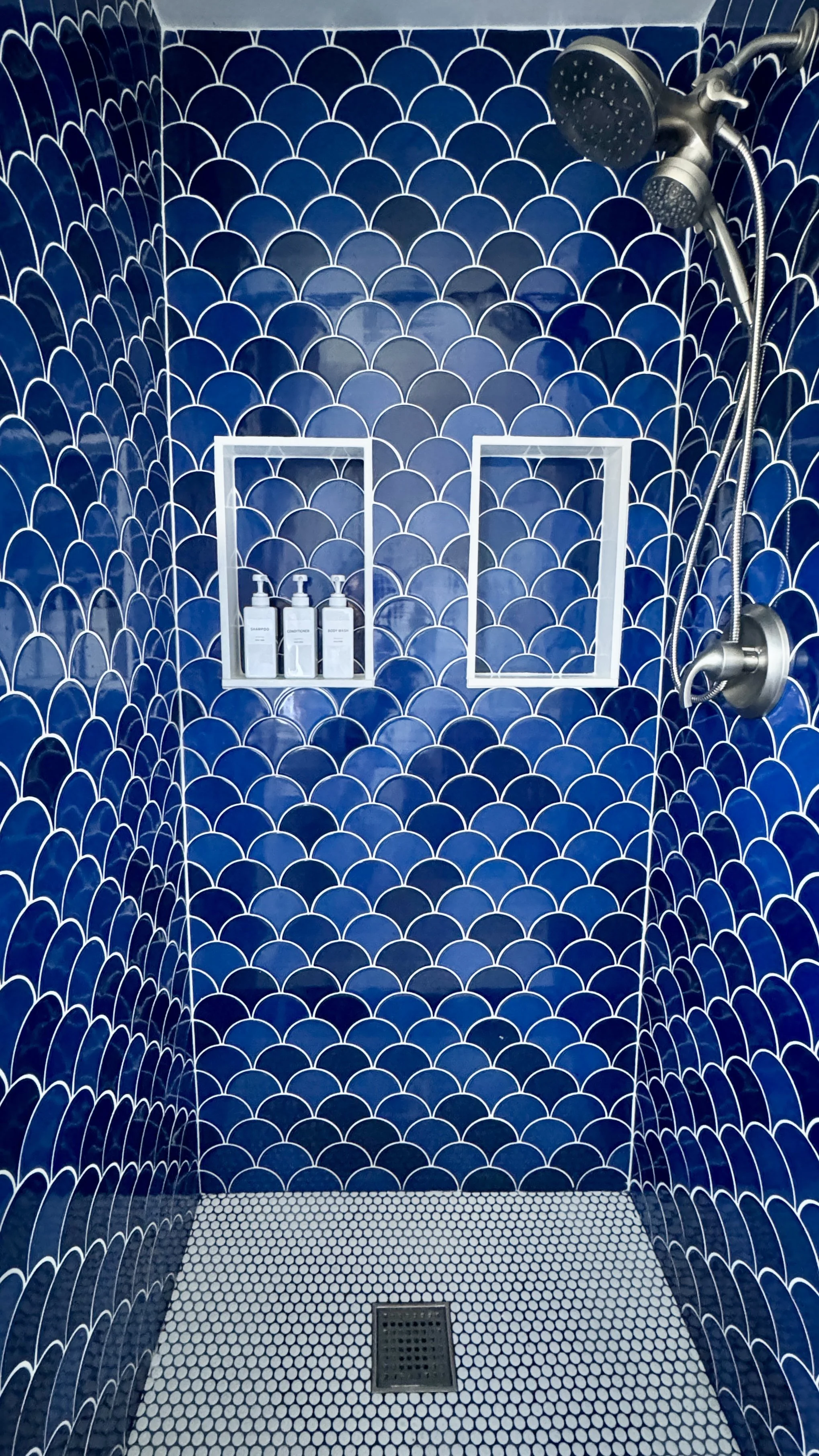 Our beautiful shower features ocean inspired tile, and a shower hose, for those who need to reach down there.