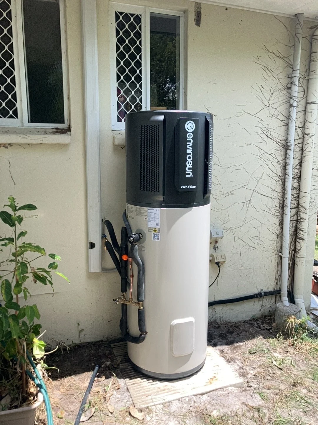 A water heater and air conditioning unit outside a house.