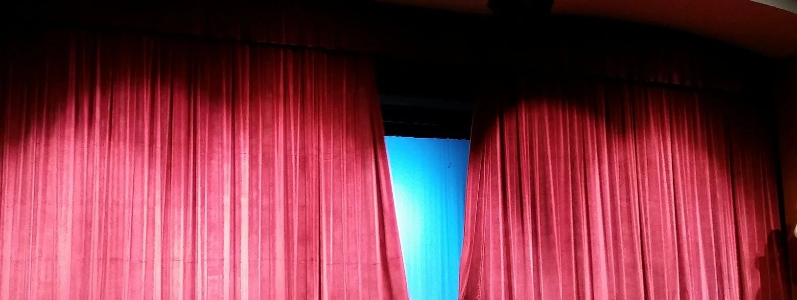 Red theater curtains opening, representing The Rehearsal Room professional development program from ArcSpan Mediation and Conflict Solutions