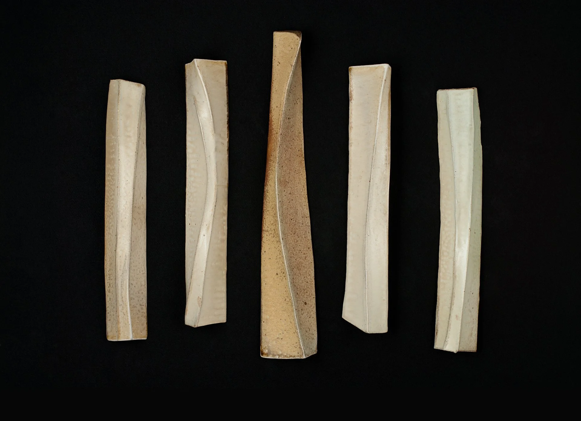 Five vertical forms with curved edges arranged on a black background.