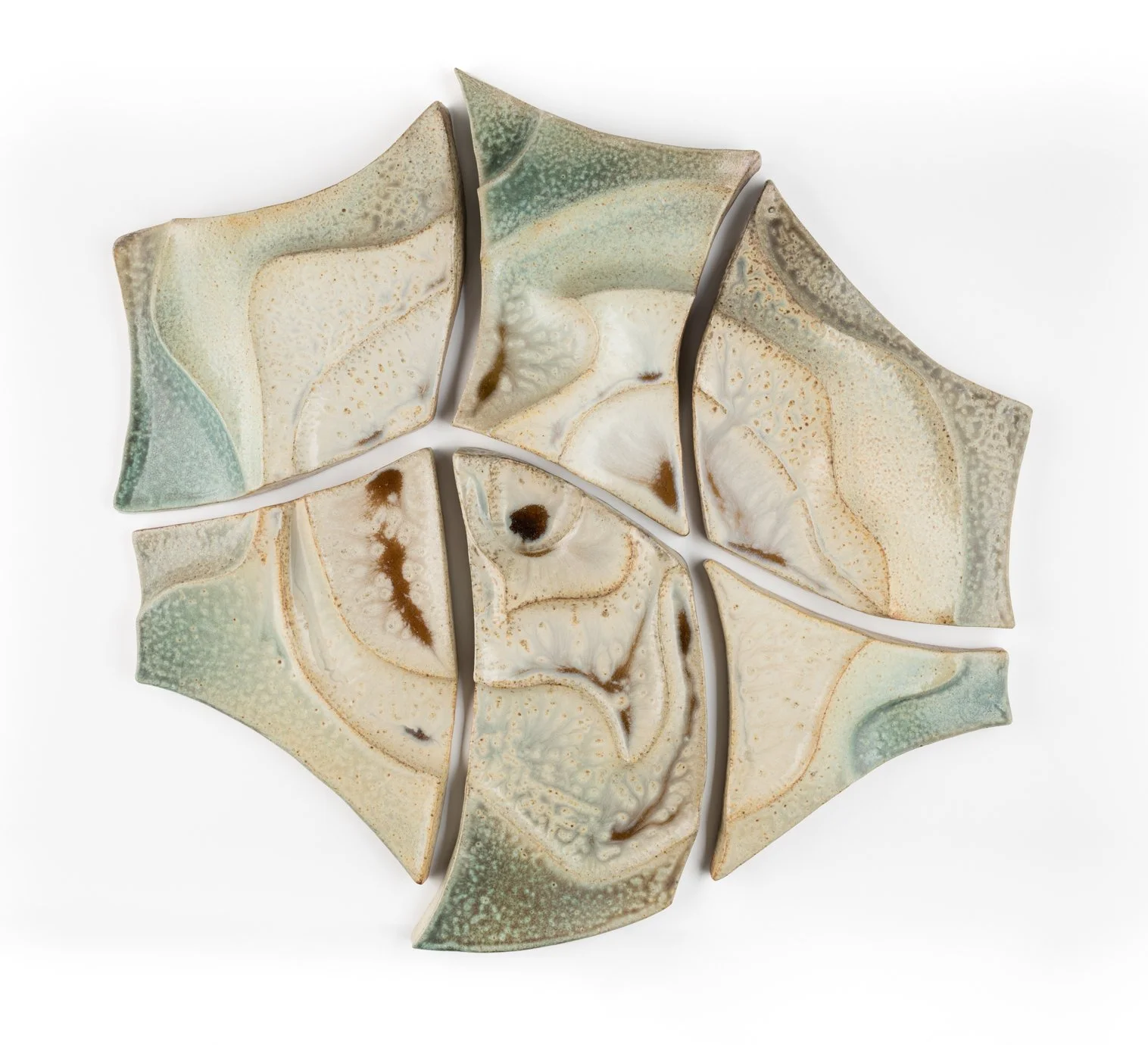 Six glazed ceramic pieces arranged in a hexagonal pattern, featuring abstract swirls in shades of cream, beige, green, and brown.