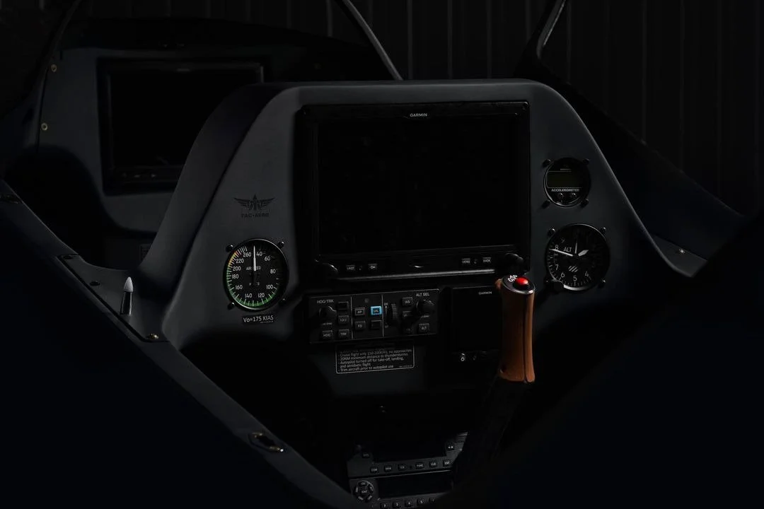 Interior cockpit of an aircraft with flight instruments, a GPS screen, and a control stick.