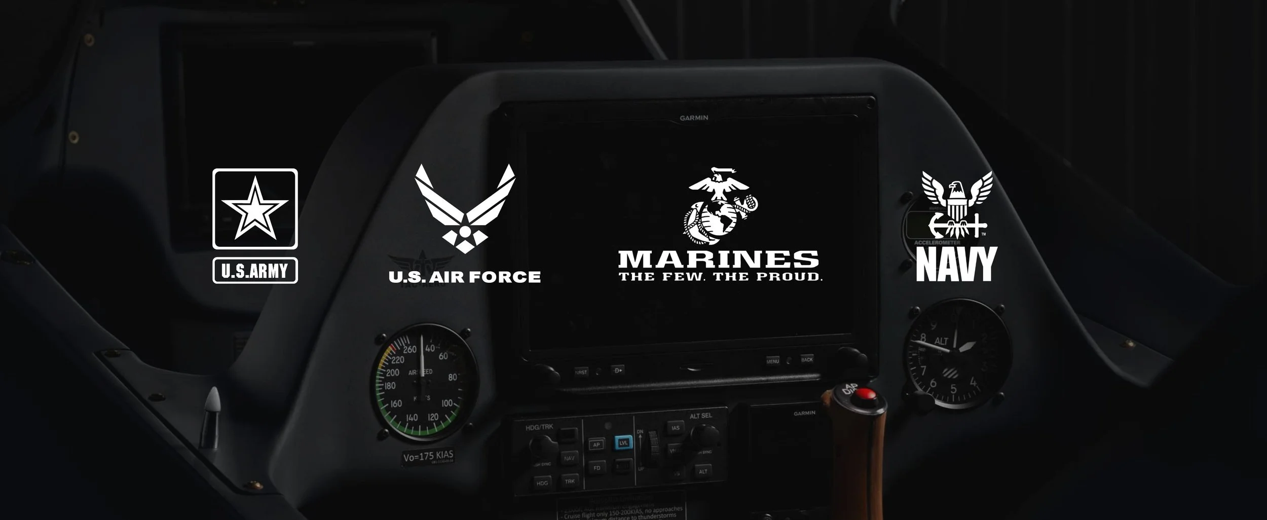 Interior of an aircraft cockpit with U.S. military branch logos on displays: U.S. Army, U.S. Air Force, Marines, and Navy.