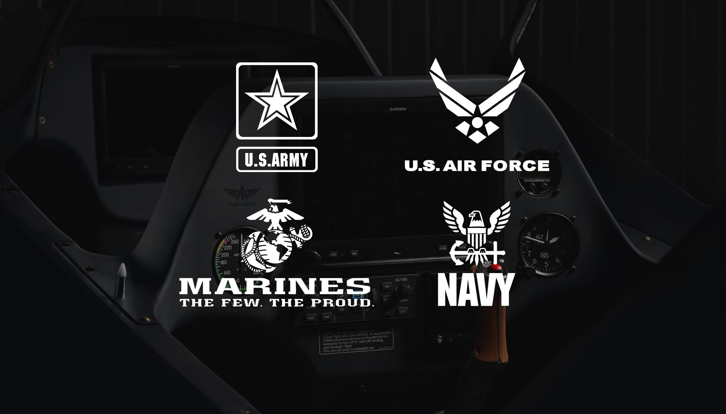 Photo of a cockpit with military service branch logos and insignias for U.S. Army, U.S. Air Force, Marines, and Navy, displayed on the dashboard.