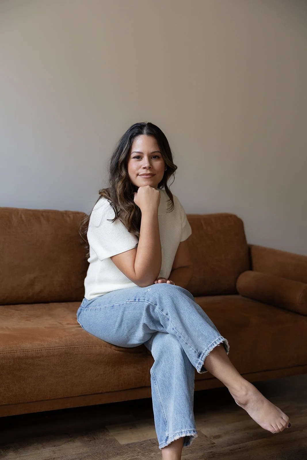 Licensed Marriage and Family Therapist in CT , Gily Roselle, perinatal therapist sitting on therapy couch.