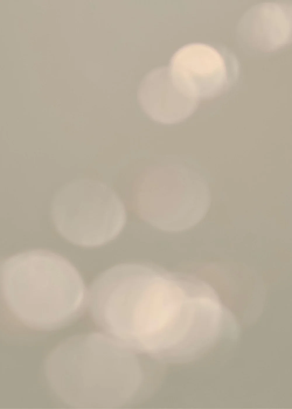 Blurred bokeh lights on a light taupe background.