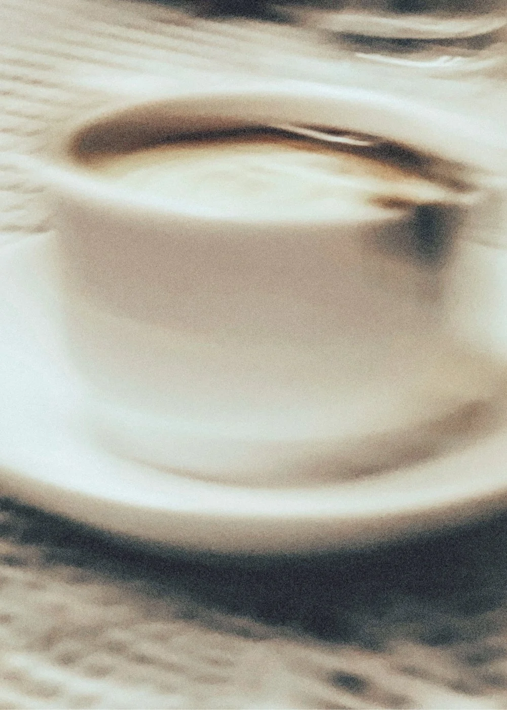 Close-up of a cup of coffee on a textured surface.