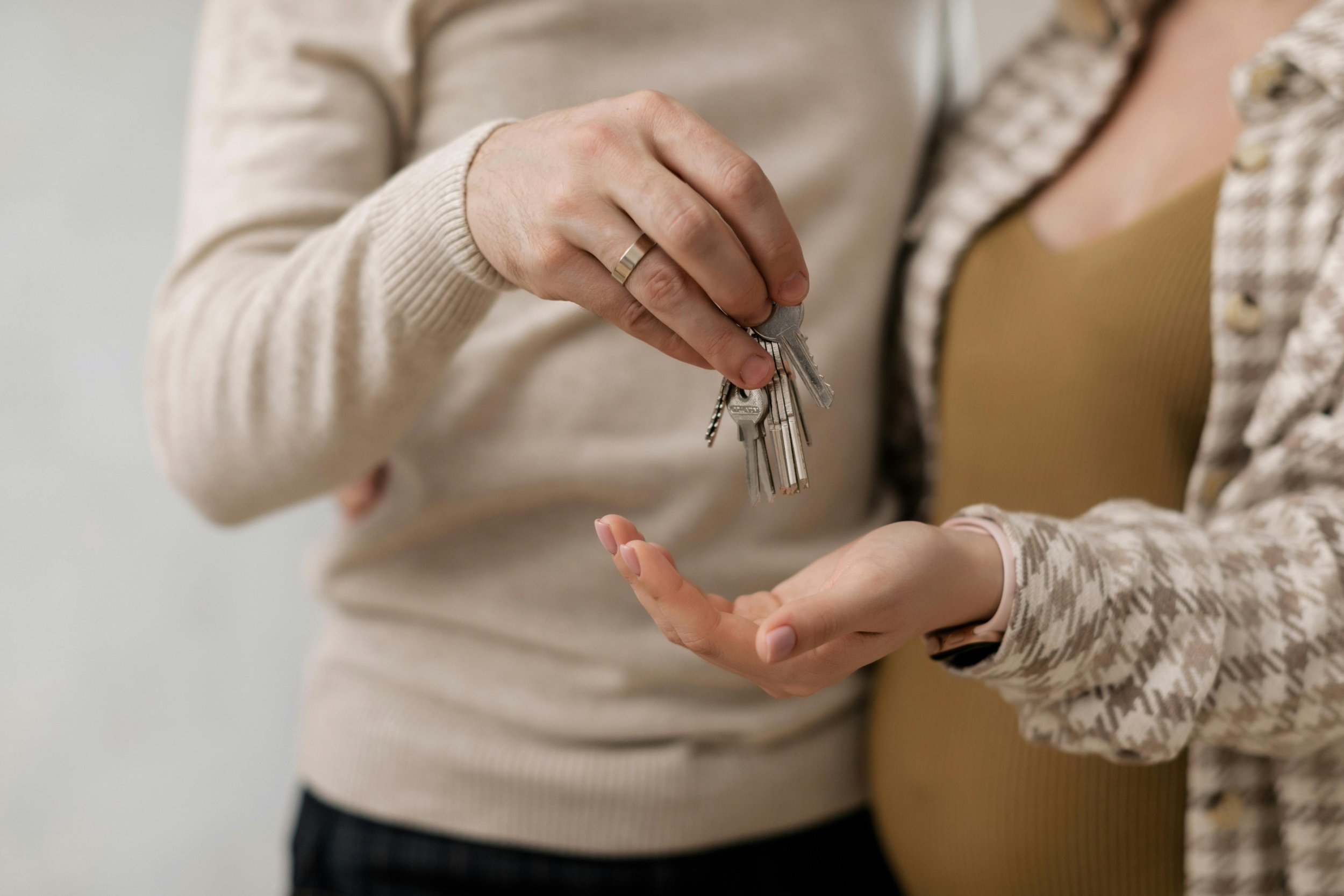 New home owners. One person handing keys to another person.