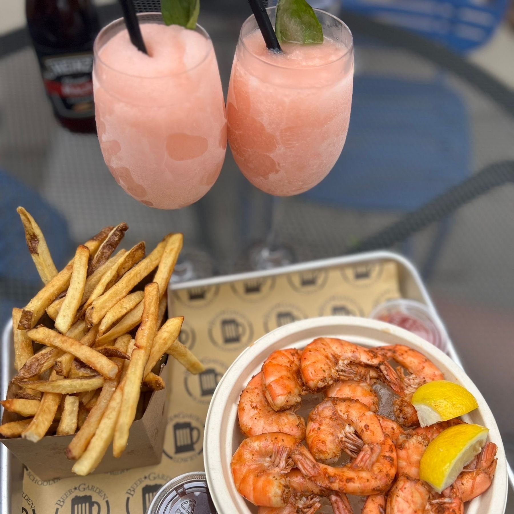 Chilled peel-and-eat shrimp and fries plated outside at a beer garden