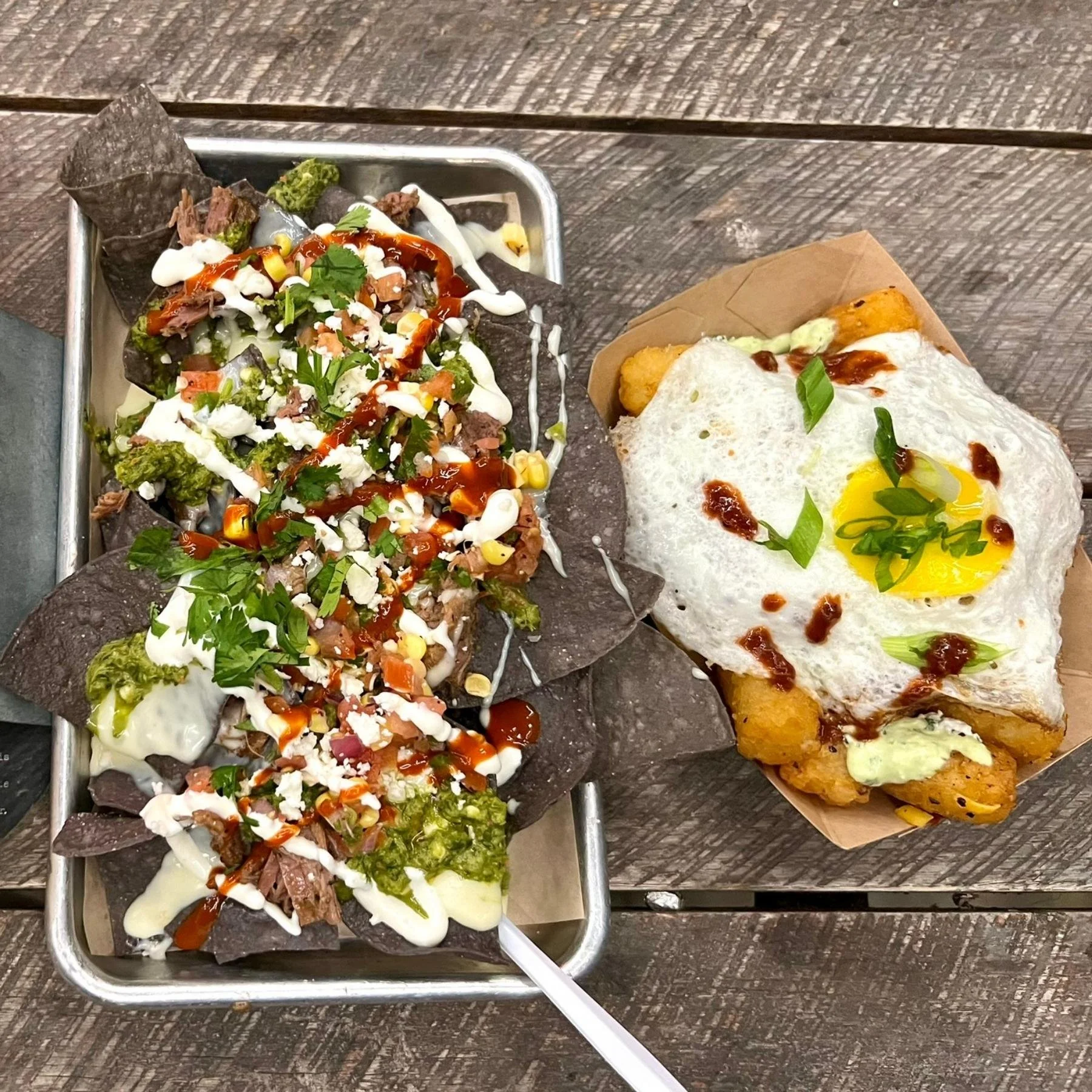 Loaded nachos and street tacos photographed outside on a patio