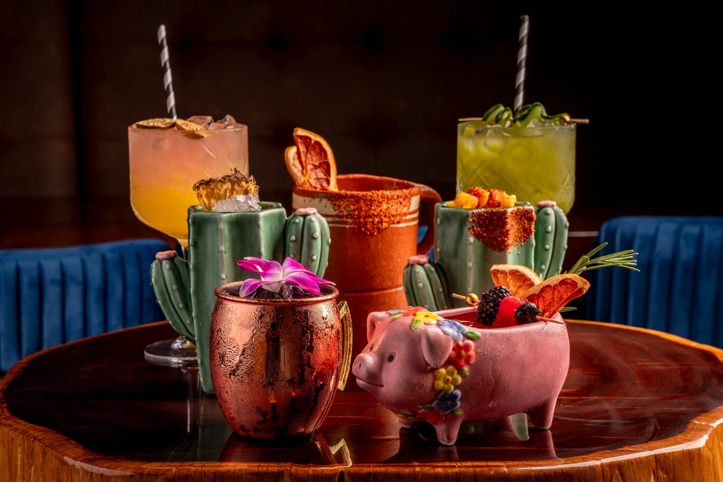 Colorful cocktails and desserts on a dark wooden table.