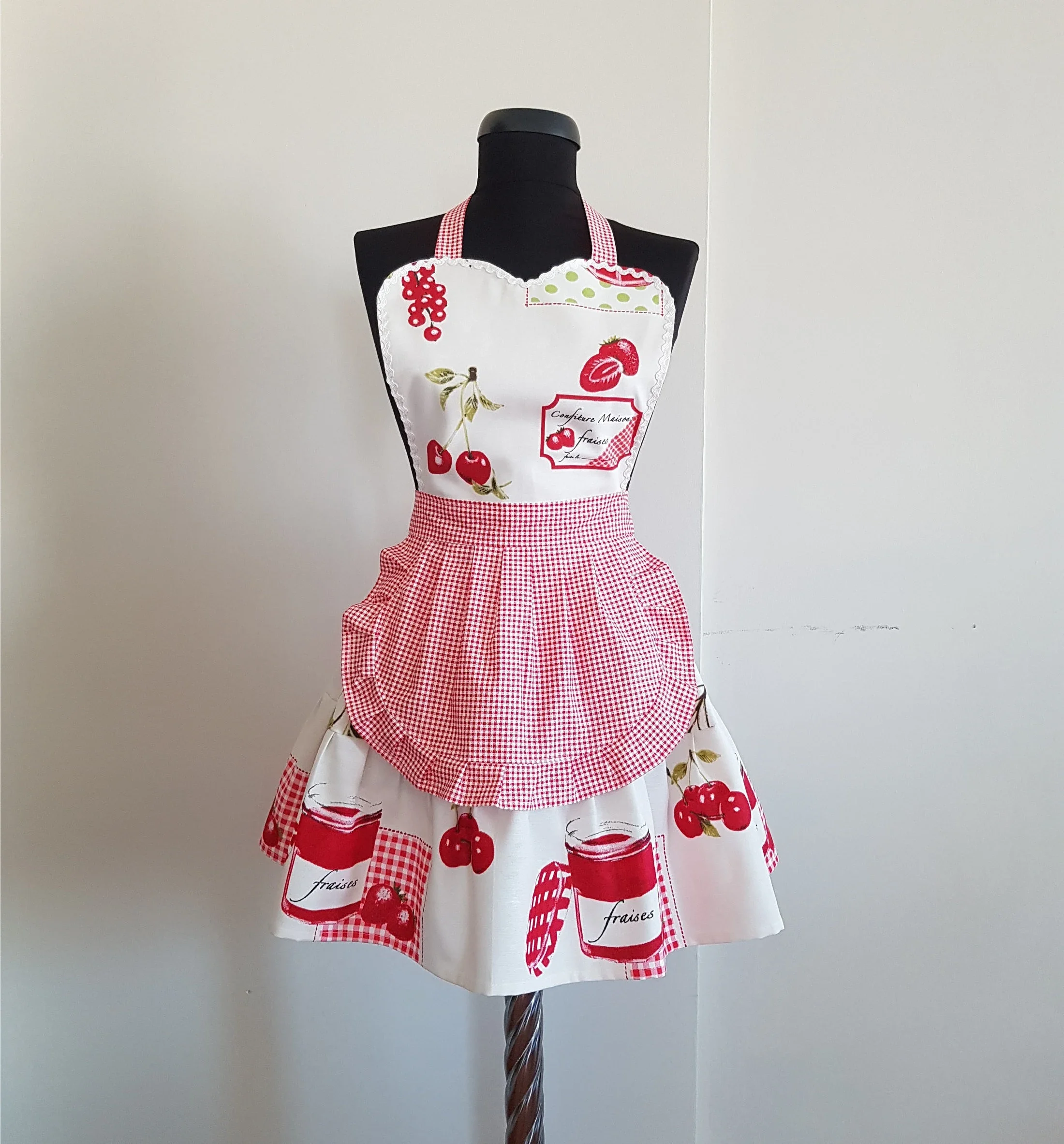 Mannequin wearing a cherry-themed apron with red and white checkered patterns.