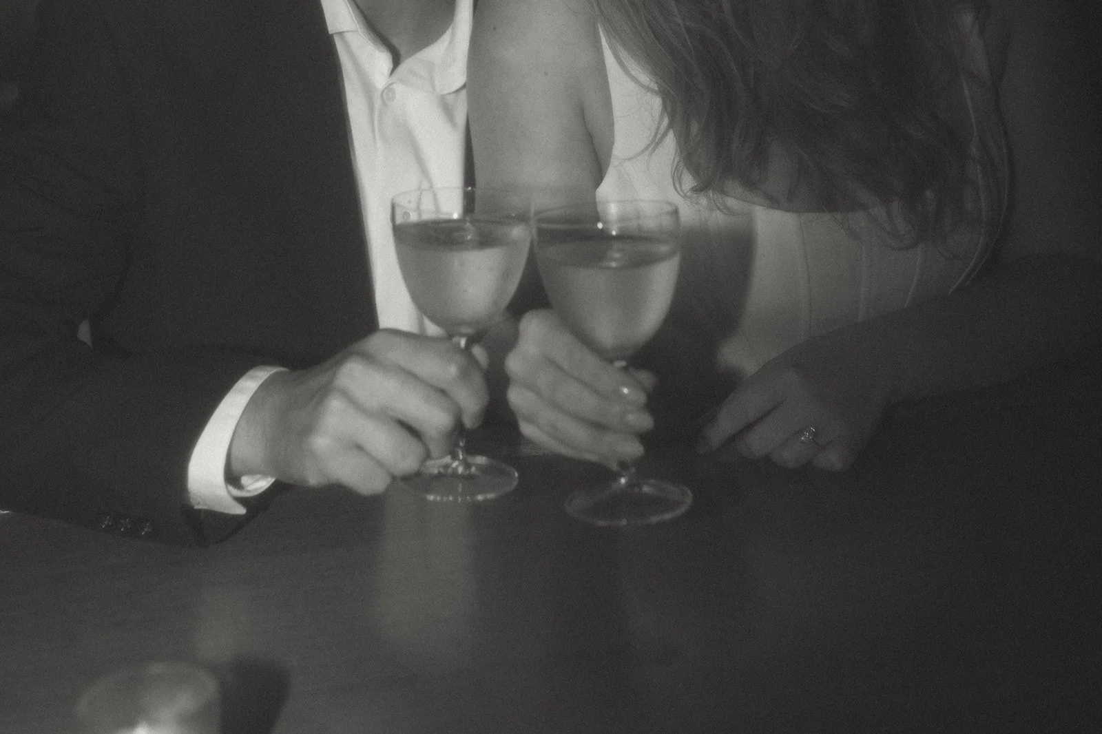 A bride and groom holding glasses of champagne in a toast at a wedding reception.