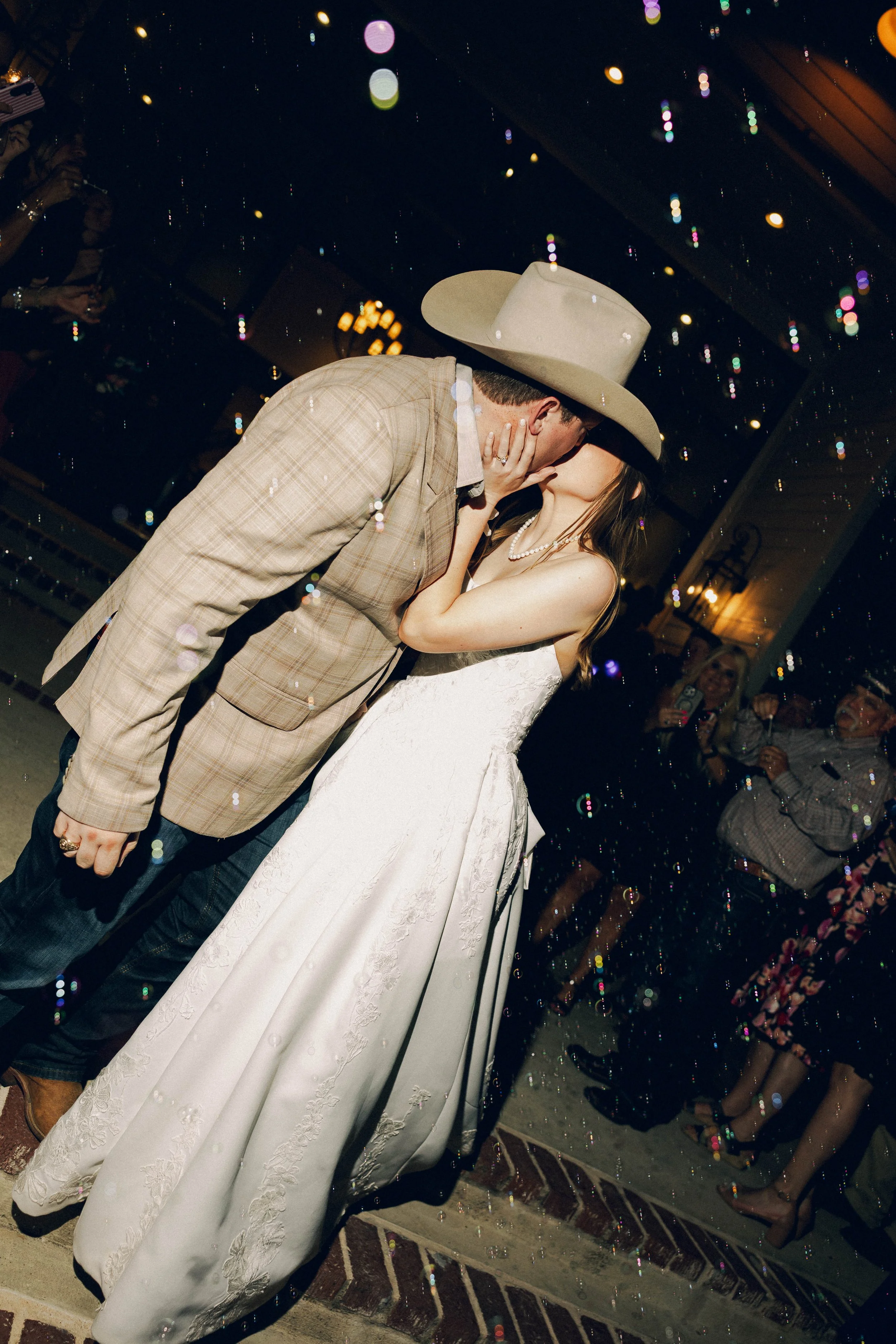 Wedding exit, bubbles, kissing, getaway car. Deep in the Heart Farms is a charming wedding venue in Brenham, Texas, known for its scenic countryside views, elegant event spaces, and romantic atmosphere. Located between Houston and Austin.