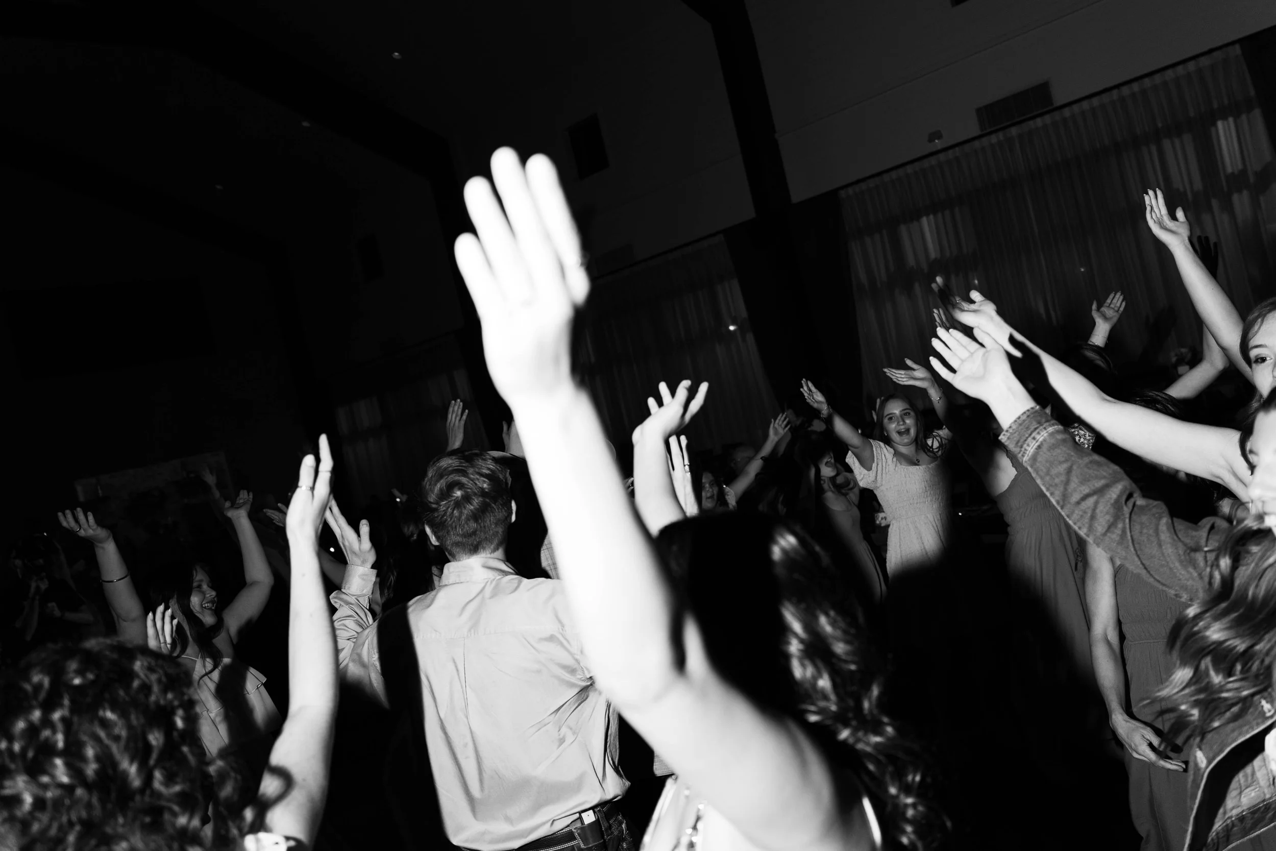 People dancing with hands raised at a party or celebration.
