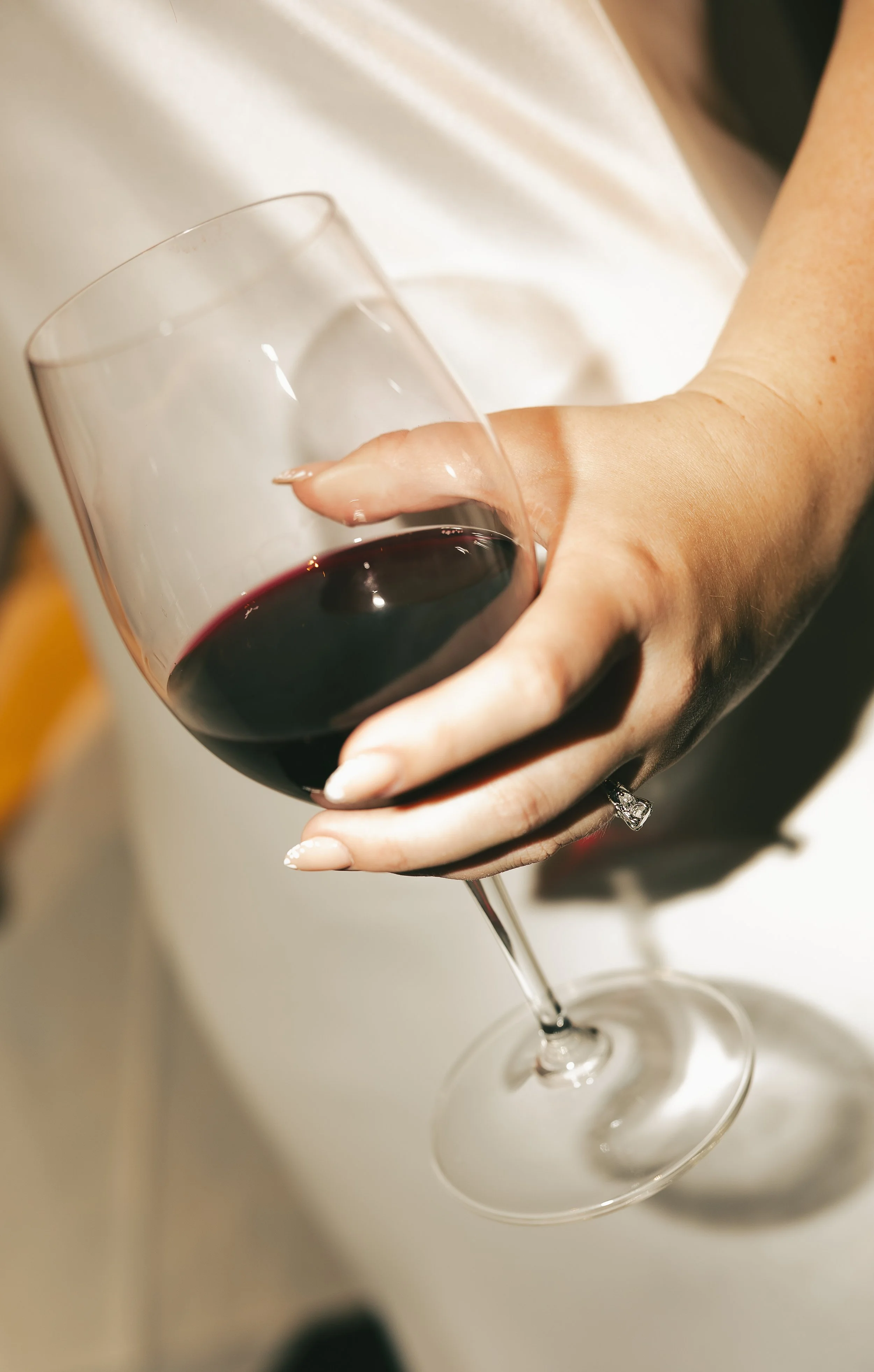 Person holding a glass of red wine