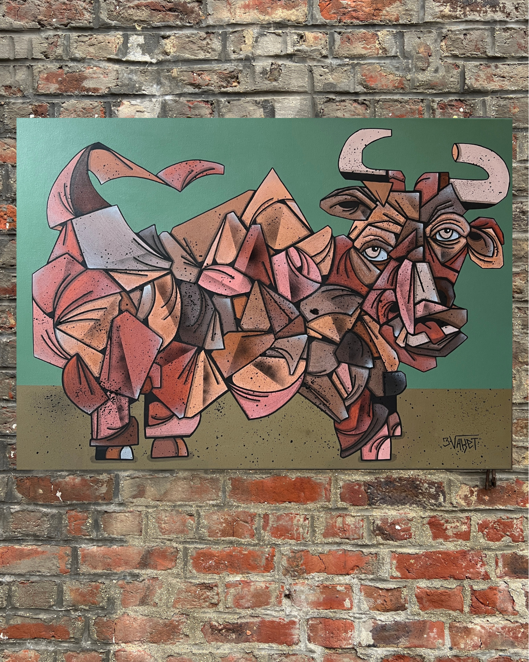 Une œuvre d'art abstraite représentant un bison, avec des formes géométriques colorées dans des tons marron, rose, et noir, avec un fond vert.