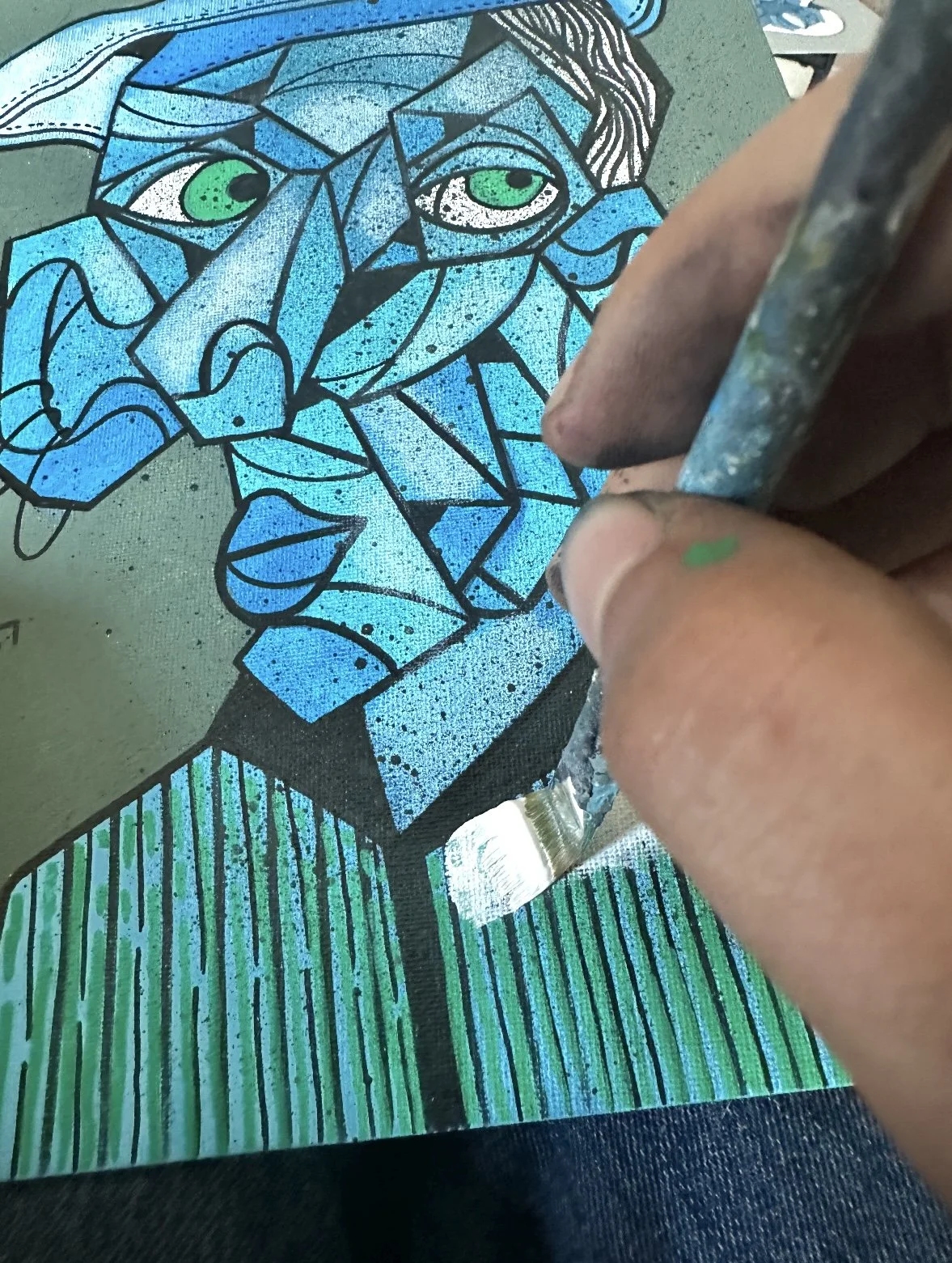 Une personne en train de colorier un tableau qui représente un portrait de style cubiste d'une femme avec un fond vert et des rayures verticales colorées en vert et bleu.