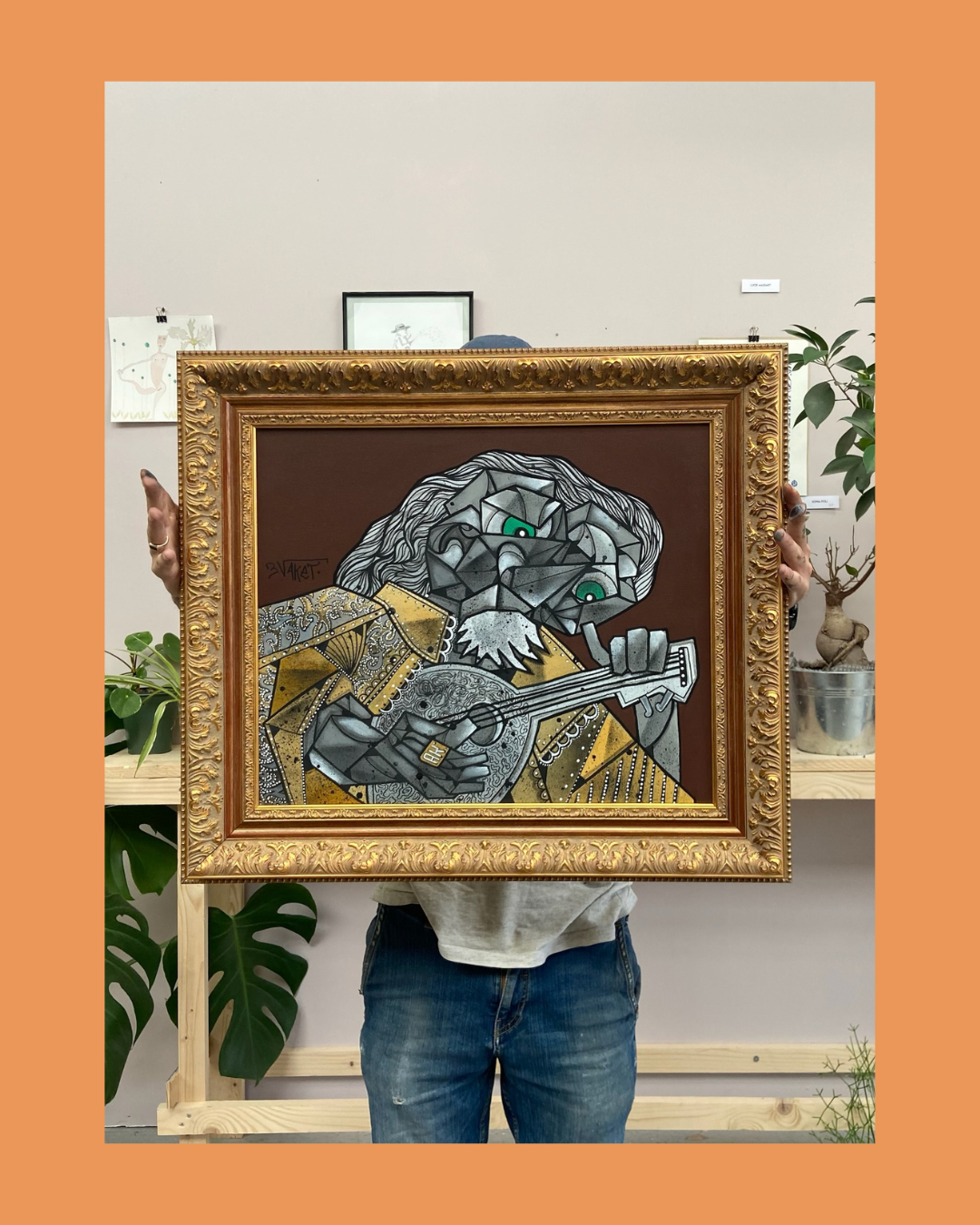 Personne tenant un tableau représentant un singe style cubisme, jouant de la guitare, dans une galerie d'art.