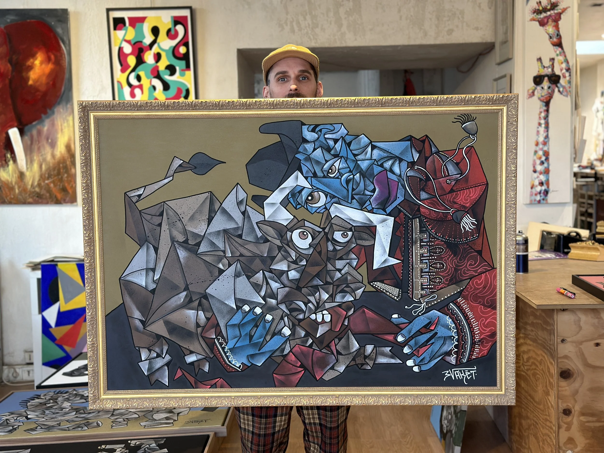 Artiste montrant une peinture cubiste représentant un chien et un humain dans un style géométrique et coloré.