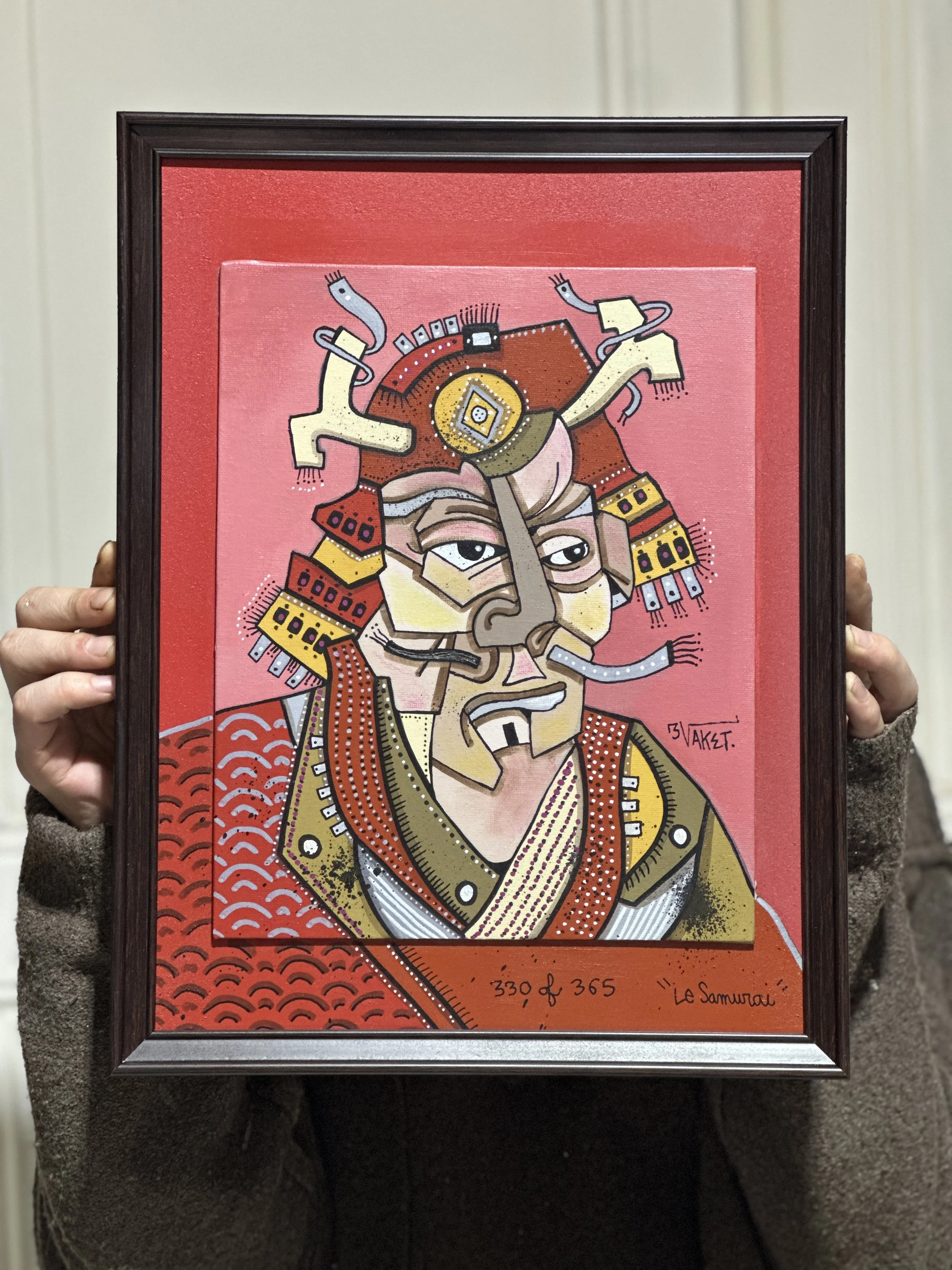 Peinture colorée représentant un samouraï avec un visage expressif, portant des vêtements traditionnels, sur un fond rouge avec un motif de vagues. Signature de l'artiste, LIAKET, en bas à droite, avec la mention 330 d. 365 'Le Samouraï'.