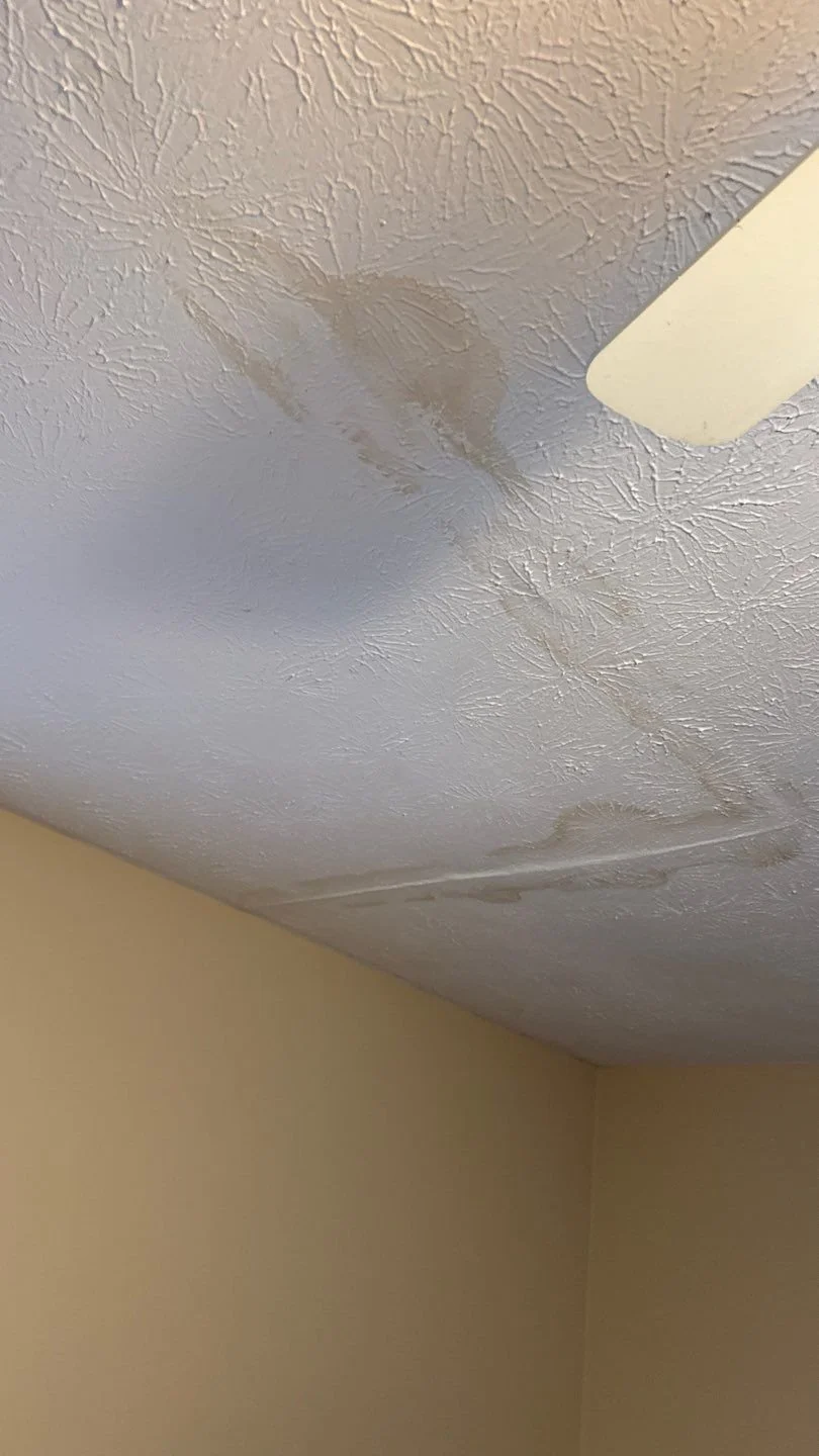 A white residential ceiling showing a large, spreading brown water stain and bubbling paint, which is a common symptom of a roof leak. CAMCO Roofing Services offers 24/7 emergency leak detection and roof repair in Rome, GA and Floyd County.