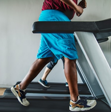 People running on a treadmill in a gym.